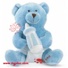 Oso azul suave del bebé con la botella de alimentación